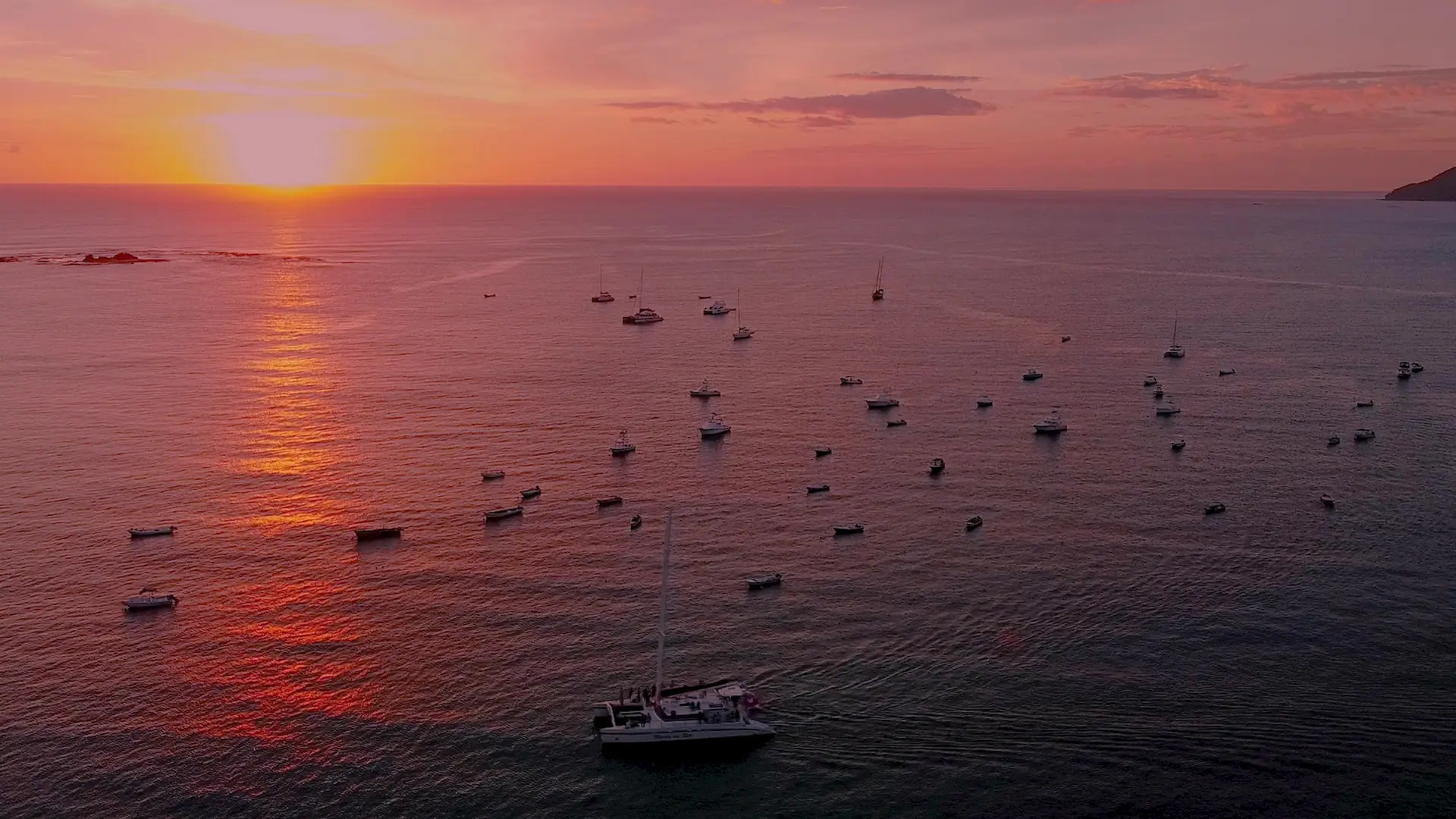 Golden sunset over a bay full of boats on Guanacaste's Gold Coast