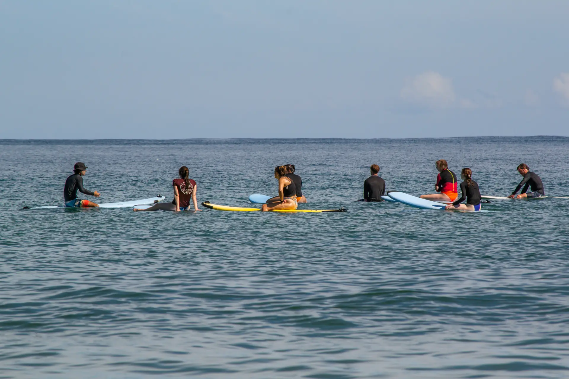 Kids sitting on surfboards in the water during a surf lesson